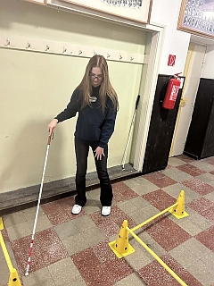 Az iskola folyosóján közlekedési akadálypályán fehér bot segítségével tájékozódik egy tanuló